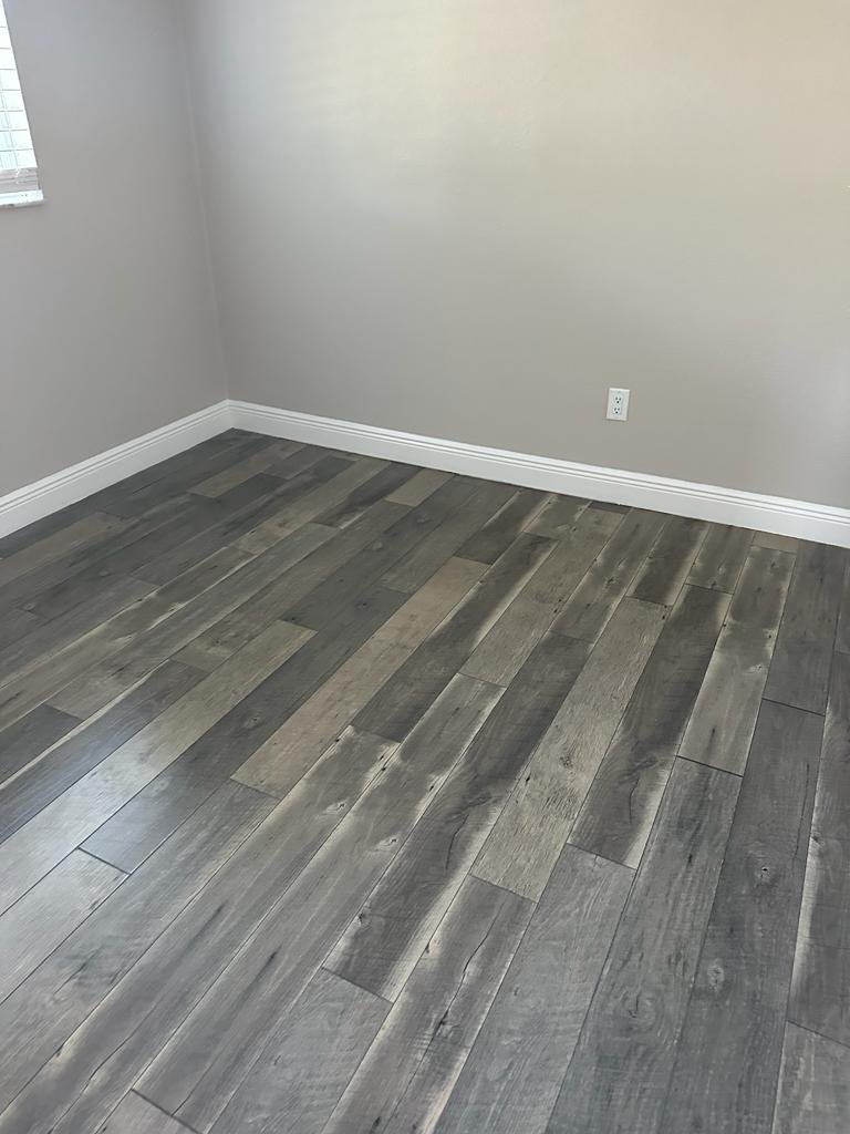Room with gray wood-look flooring before final finishing