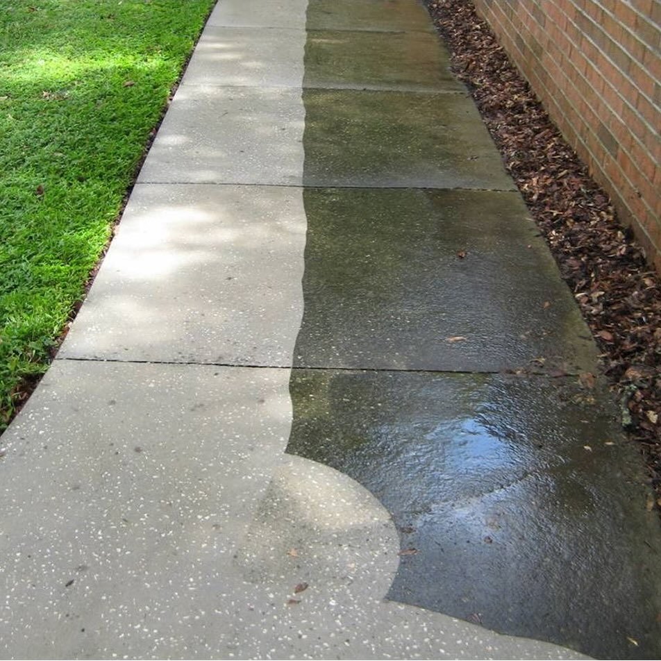 Concrete sidewalk, half cleaned and half still dirty from pressure washing
